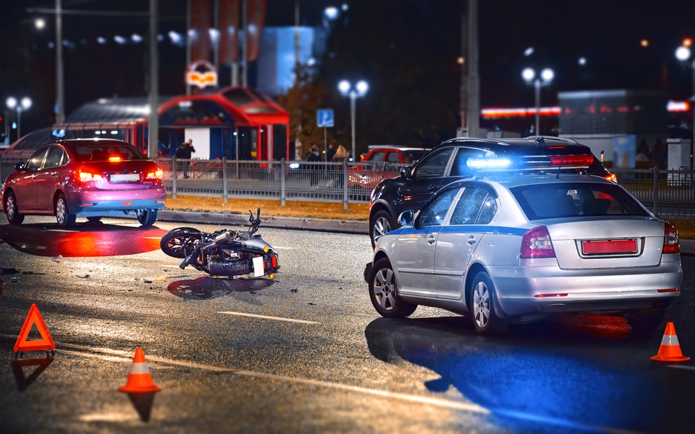 A motorcycle is on the ground in the middle of a wreck after being involved in a accident